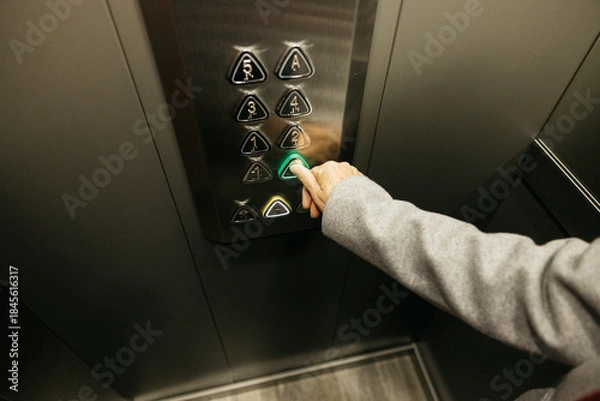 Obraz Senior hand pressing elevator button choosing floor
