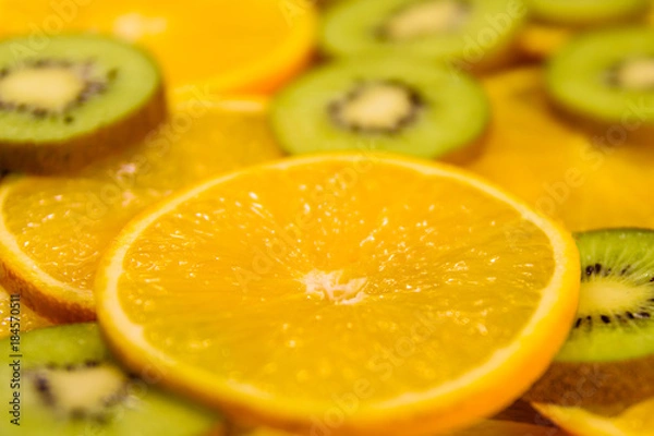 Fototapeta Background of the kiwi and orange fruits. Selective focus