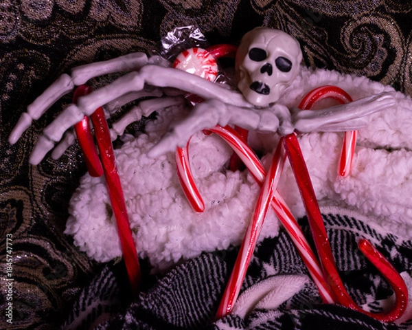Fototapeta A haunted Christmas scene featuring peppermints, candy canes, skulls and a skeleton hand. 
