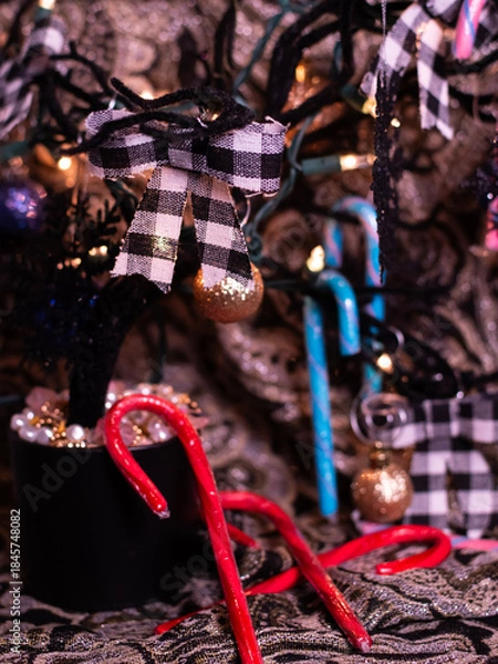 Fototapeta Candy canes, Christmas bows and pearls. The theme of the Christmas tree is black, gold and white with an accent of red.