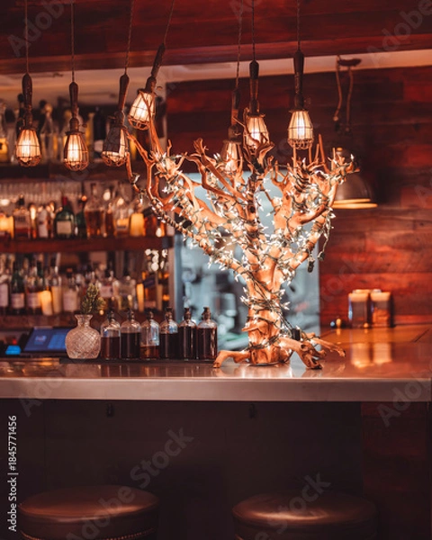 Obraz Rustic Bar Interior with Decorative Tree Wrapped in Warm String Lights
