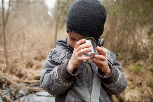 Obraz Boy examining something in a glass
