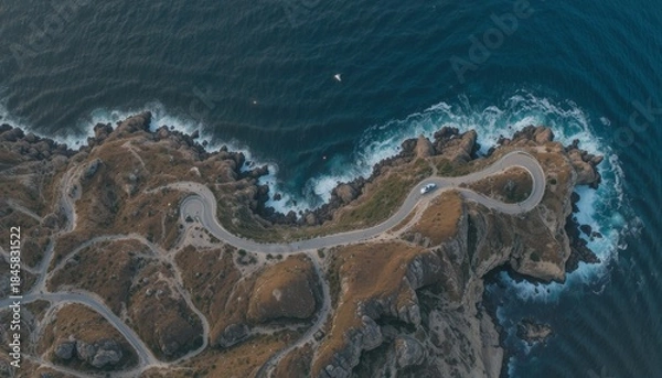 Fototapeta Aerial view of winding coastal road along dramatic cliffs and deep blue ocean