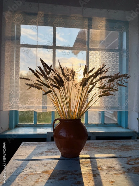 Obraz Dried grass in rustic vase catching sunset light