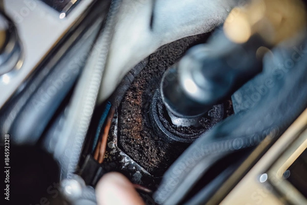 Obraz Mechanic's hand installing or repairing the center console trim around the gear shift lever inside a vintage car.