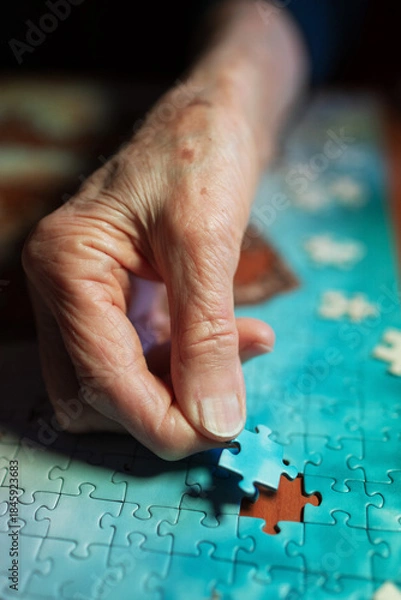 Obraz Elderly woman assembling a jigsaw puzzle