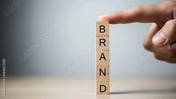Obraz Building a strong brand identity concept with wooden letter blocks and a hand
