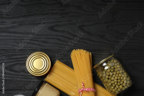 Fototapeta Humanitarian aid. Different food products for donation in crate on wooden table