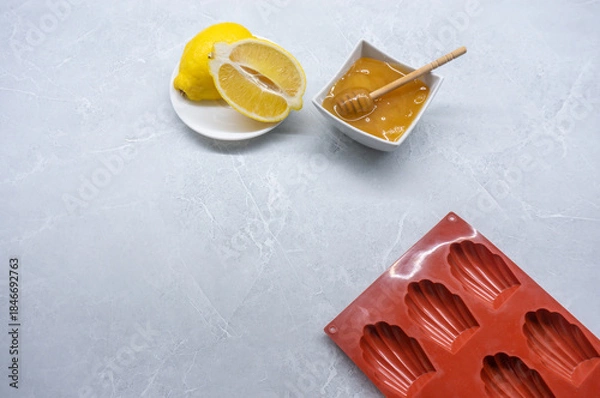 Fototapeta Madeleine mold and ingredients on a marble table. Top View. Space for Text.