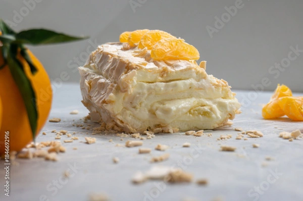 Fototapeta Meringue roll with cream and tangerines. Close-up.