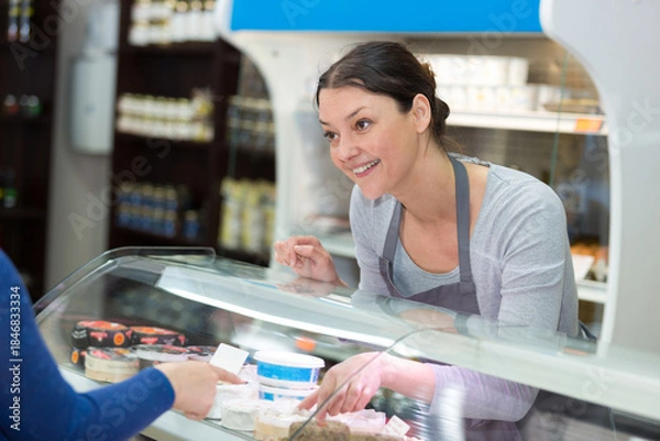 Obraz sales clerk serving at cheese counter