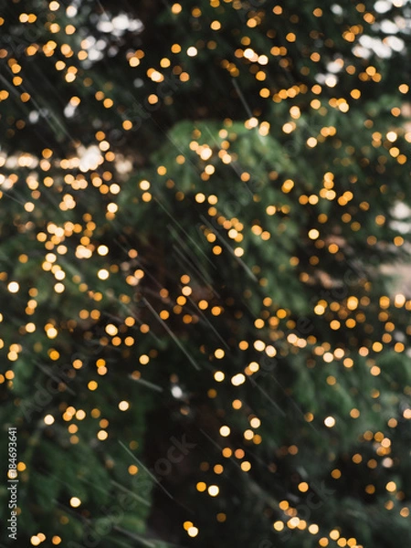 Fototapeta Blurry, golden Christmas fairy lights on outdoor christmas tree at the castle of Nuremberg in the snow during winter creating a beautiful bokeh effekt
