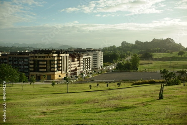Fototapeta View of the La Florida district in Oviedo in soft afternoon light with green lawns of a city park 