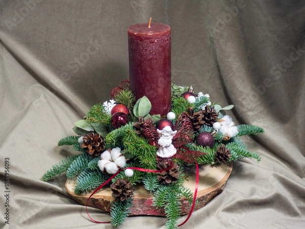 Fototapeta Christmas table decoration with red candle and white angel. Christmas greeting card. Advent wreath design