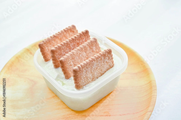Fototapeta 容器入ったヨーグルトにサブレを刺す