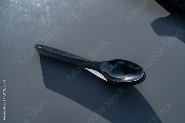 Obraz Stack of metal spoons with sky reflections placed on light surface.