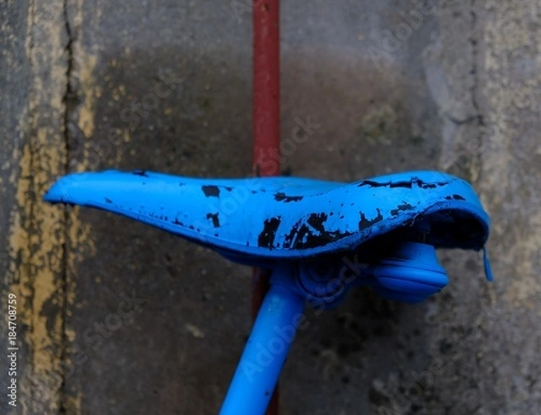 Obraz old blue bicycle saddle in front of a wall