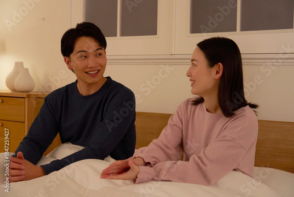 Obraz ベッドの上で会話する夫婦