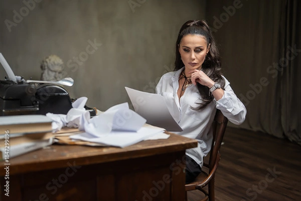 Obraz A female writer works at a typewriter, writing an essay.