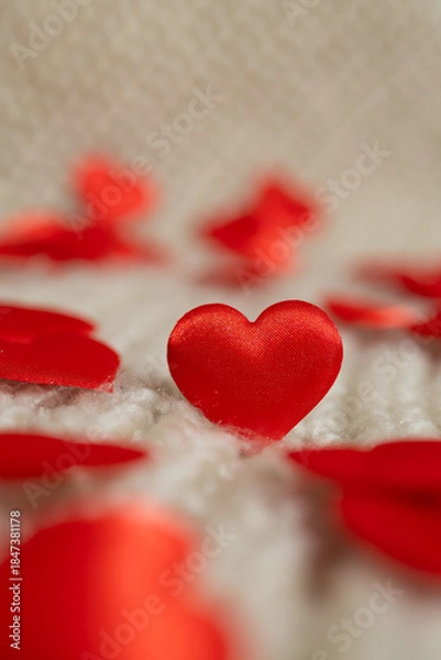 Obraz Red fabric hearts are scattered across a soft, textured white surface. The hearts vary in focus, creating a depth of field effect, perfect for Valentine's Day content.