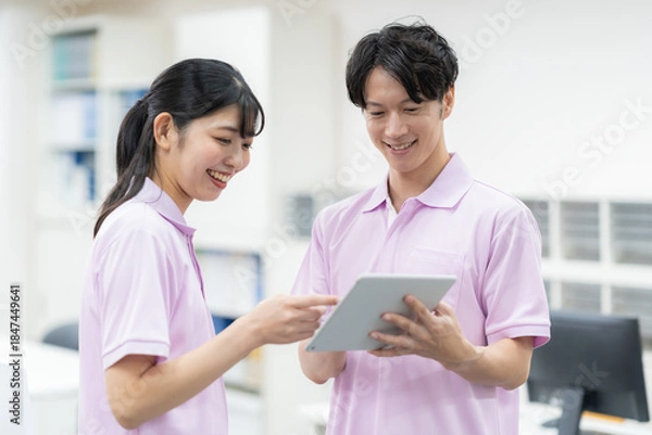 Obraz 介護施設の事務所の若い男女の介護士