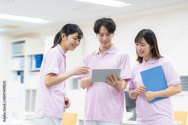 Obraz 介護施設の事務所の若い男女の介護士