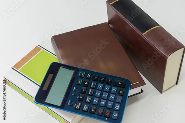 Fototapeta 電卓とビジネス書を並べた会計と計算のイメージ