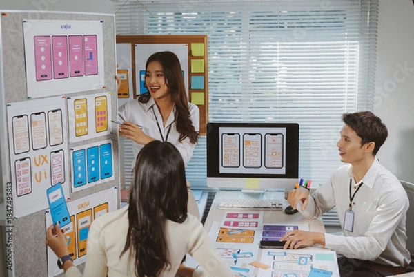 Obraz Design team brainstorming and presenting mobile user interface wireframes and concepts in a creative office meeting