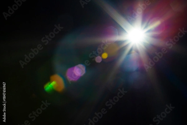 Obraz Lens flare and light multi color overlay effect on black background