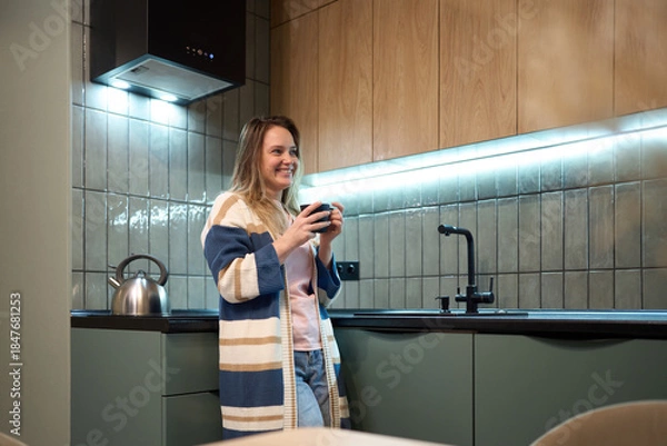 Obraz Freelancer evening routine with warm drink in modern kitchen