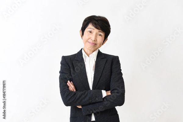 Obraz スーツ姿で腕組みをする笑顔の中高年のアジア人女性