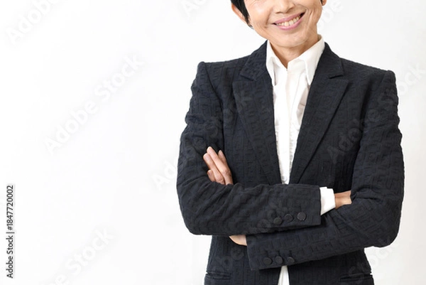 Obraz スーツ姿で腕組みをする笑顔の中高年のアジア人女性