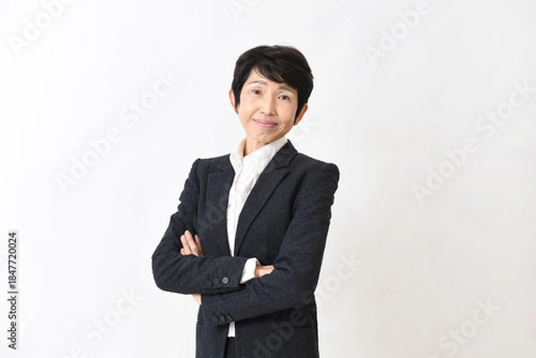 Obraz スーツ姿で腕組みをする笑顔の中高年のアジア人女性
