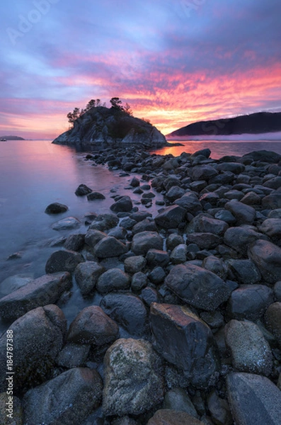 Fototapeta Fog and mist roll into Whytecliff Park at sunset producing some vivid colors in West Vancouver BC Canada.