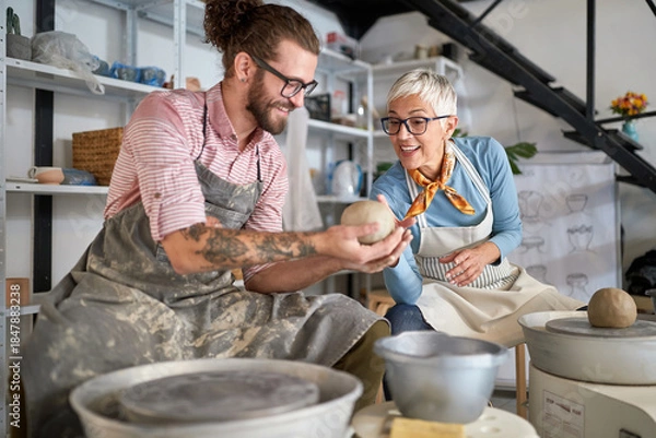 Obraz pottery workshop. beginner Making pot from clay while teacher explaining how. Creative, hobby ,activities concept