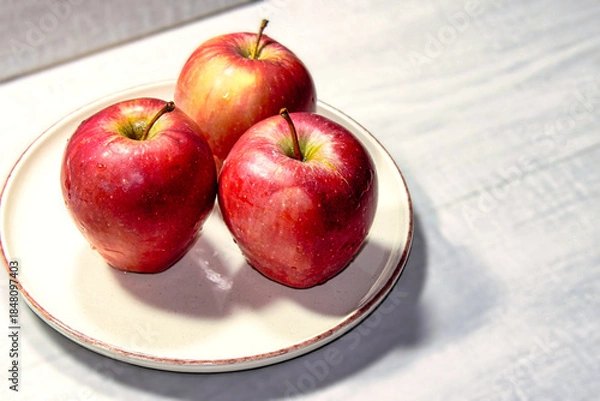 Obraz Three apples are on a white plate