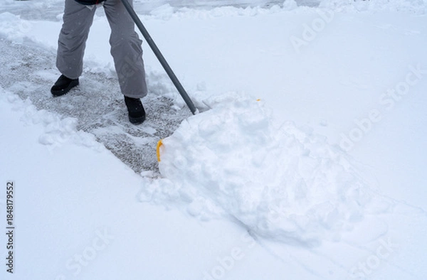 Fototapeta shoveling the snow on driveway