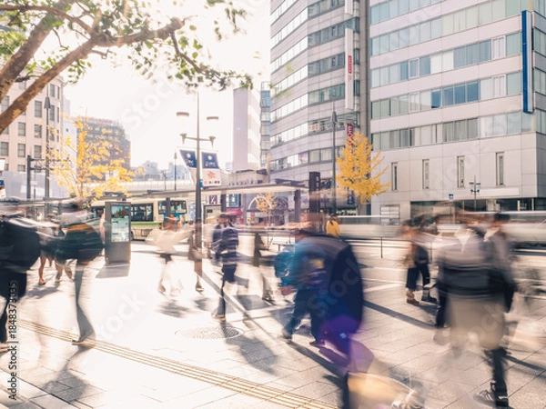 Fototapeta 歩行者が行き来する晴れた日の都市部の風景　長時間露光