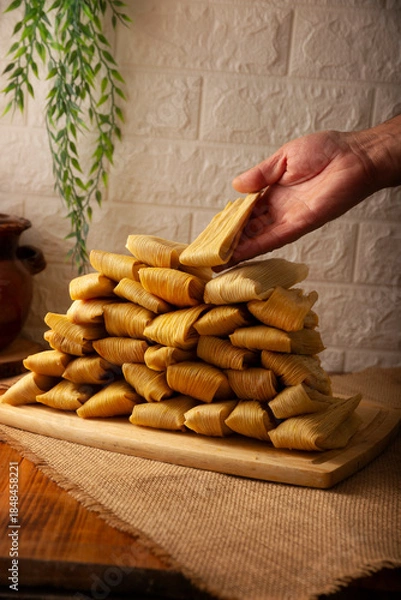Fototapeta Tamales. Traditional dish typical of Mexico and some Latin American countries. Corn dough wrapped in corn leaves. The tamales are steamed.