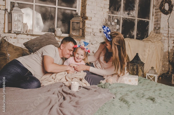 Fototapeta father mother and little daughter in pajamas having fun