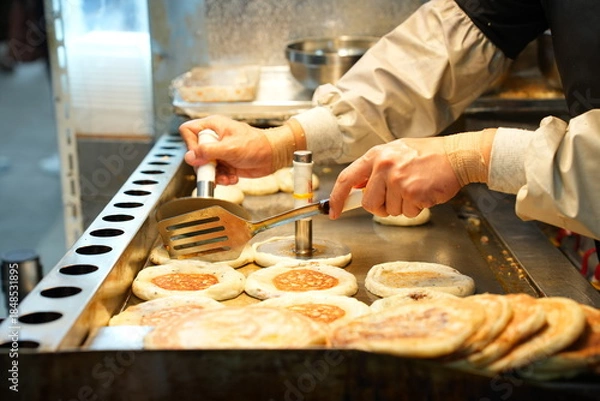 Fototapeta 뜨거운 철판 위에서 노릇하게 구워지는 한국의 겨울 길거리 음식, 호떡