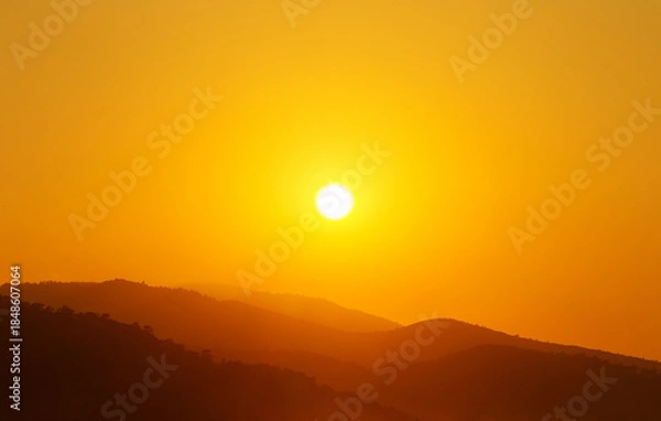 Obraz the sun rising behind a mountain
