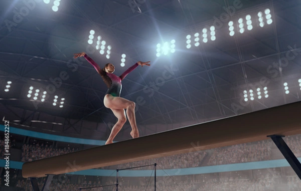 Fototapeta A gymnast performs a difficult trick on a balance beam.