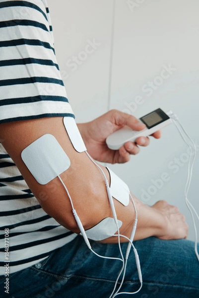 Fototapeta a man using a portable electrotherapy device