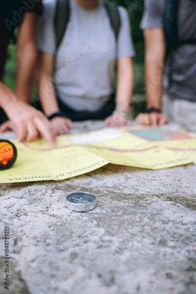 Obraz Hikers planning adventure route using map and compass