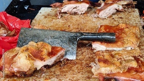 Obraz Crispy Roasted Pork Belly (Babi Guling or Lechon) Being Chopped on a Gritty Butcher's Cutting Board with a Cleaver