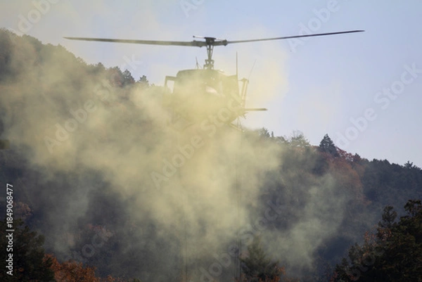 Obraz 煙の中飛ぶヘリコプター