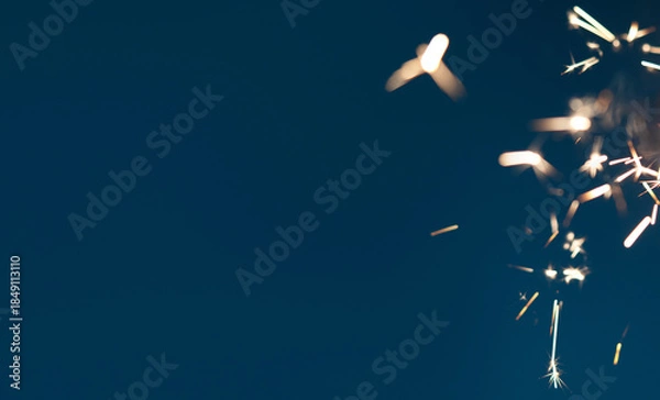 Obraz Blurred sparks from sparklers on dark backdrop with copy space. Perfect background template for holiday celebration and party-themed designs.