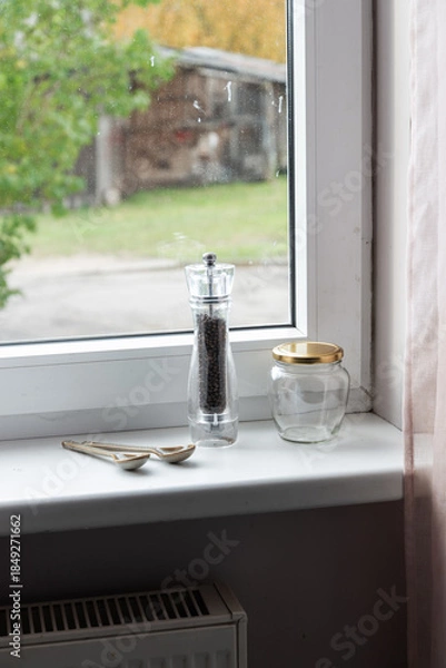 Fototapeta Empty spice jars and pepper mill on a windowsill