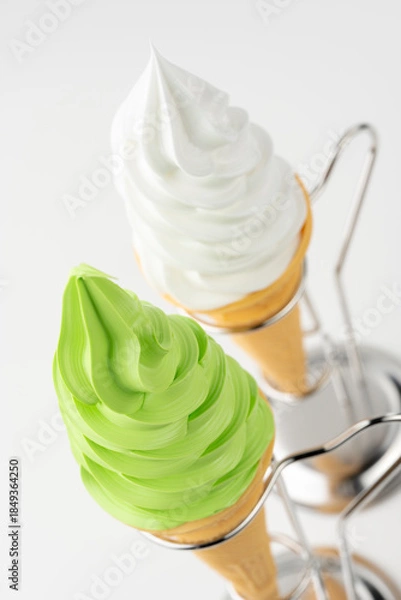 Obraz 白背景に並ぶバニラと抹茶のソフトクリームコーンと金属スタンド